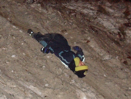 Weihnachtsbaumfeuer - Kinder rutschen im Schnee die B&ouml;schung herunter